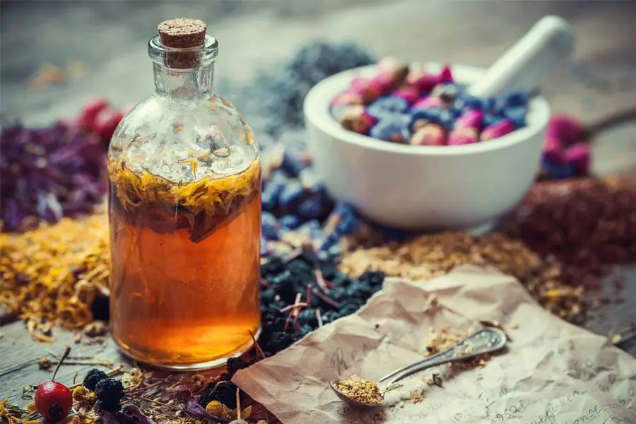 A bottle of tea and some berries on the table