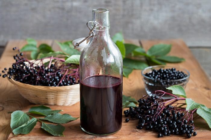 A bottle of elderberry syrup sitting on top of a table.